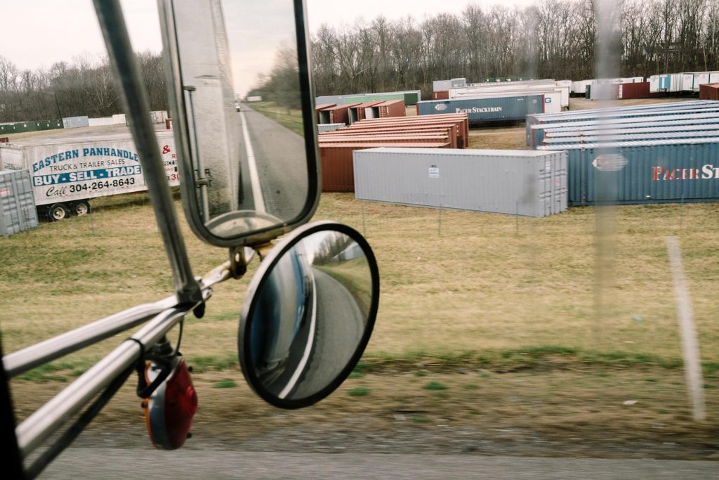 Virginia - 4/2/2015 - A storage lot for semi trailers along Interstate 81 is seen through the side window of Robert Harsell's 1989 Freightline semi tractor rolls down Interstate 81 in rural Virginia. Harsell (68) is part of a dwindling population of independent owner/operators in an economy that is steadily becoming more corporate. He feels that new safety regulations threaten their livelihood, and actually make highways more dangerous.